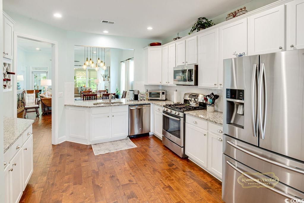 2110 Silver Spring Lane Myrtle Beach, SC 29577 - Photo 5 of 40 Kitchen with stainless steel appliances, dark wood-type flooring, white cabinetry, recessed lighting, and light stone countertops