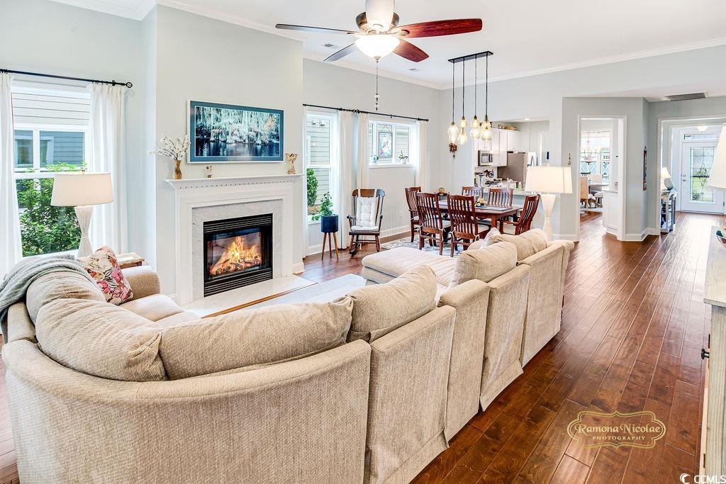 2110 Silver Spring Lane Myrtle Beach, SC 29577 - Photo 8 of 40 Living room featuring a ceiling fan, dark wood-style flooring, a glass covered fireplace, and ornamental molding