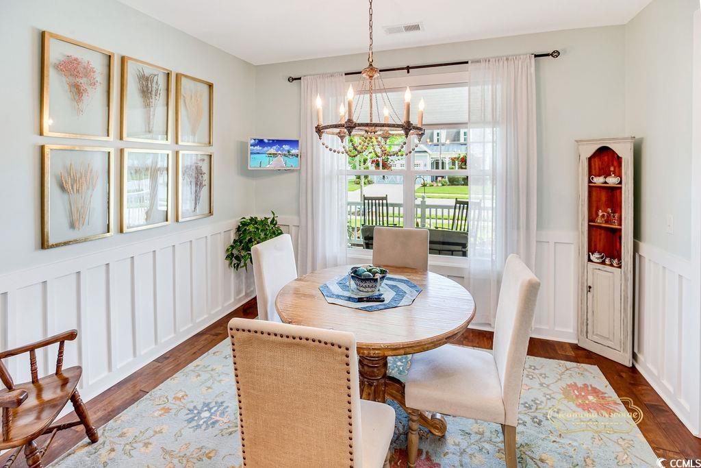 2110 Silver Spring Lane Myrtle Beach, SC 29577 - Photo 10 of 40 Dining area with a chandelier, dark wood finished floors, wainscoting, and a decorative wall