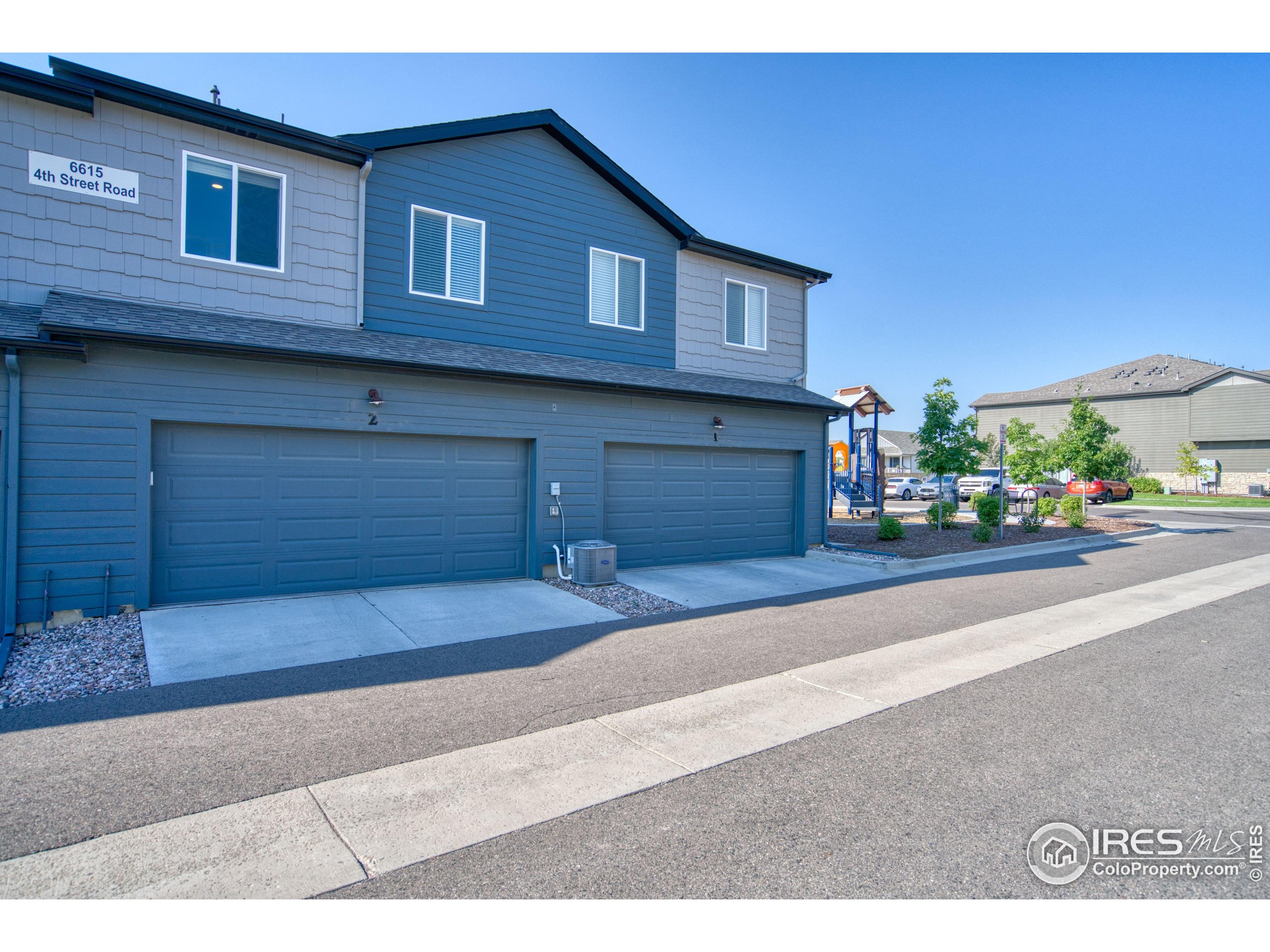 6615 4th St Road, Unit 2 Greeley, CO 80634 - Photo 24 of 31 a front view of a house with a yard and garage