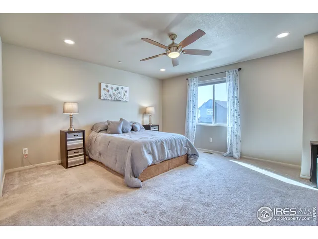 a bedroom with a large bed and a ceiling fan