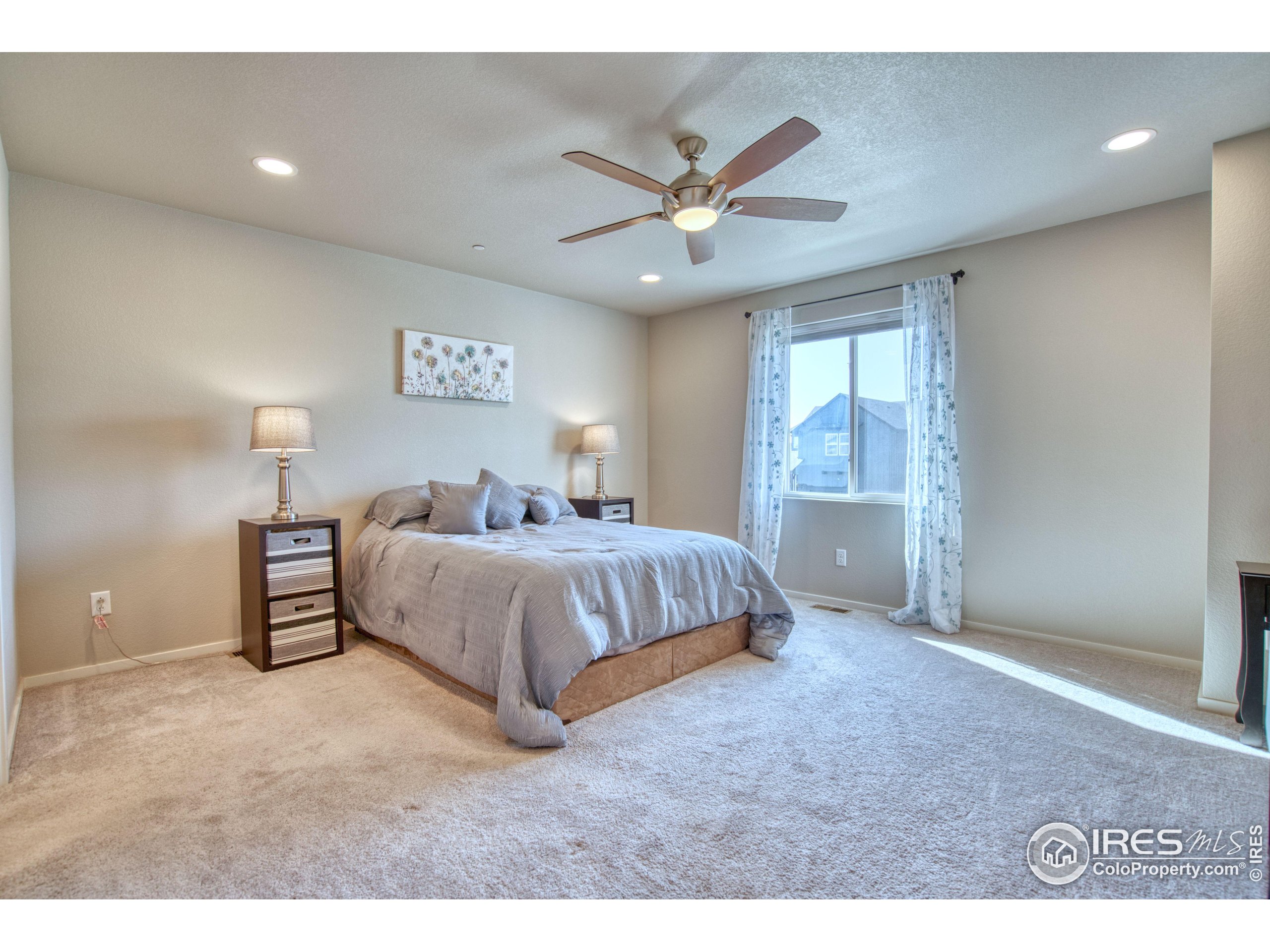6615 4th St Road, Unit 2 Greeley, CO 80634 - Photo 8 of 31 a bedroom with a large bed and a ceiling fan