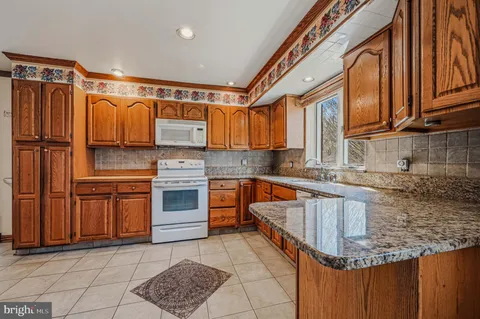 a kitchen with stainless steel appliances granite countertop a stove sink and cabinets