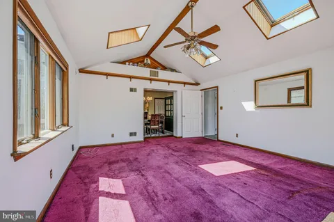 a view of a big room with wooden floor and windows