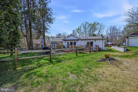 a view of a house with a garden and trees