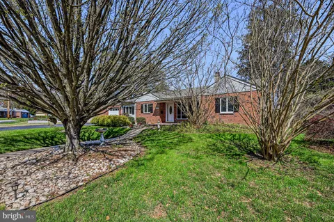 a view of a house with a backyard and a tree