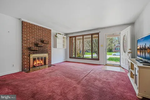 a view of an empty room with a fireplace and a window
