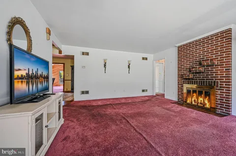 a view of an empty room with a fireplace and a flat screen tv