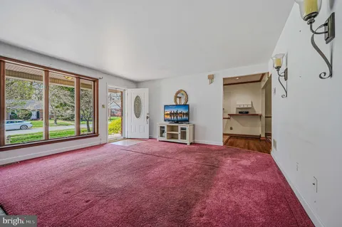 a view of empty room with a window and a kitchen