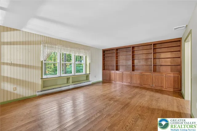 an empty room with windows and cabinet