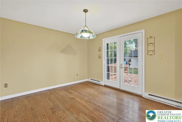 a view of a hallway with wooden floor and a chandelier