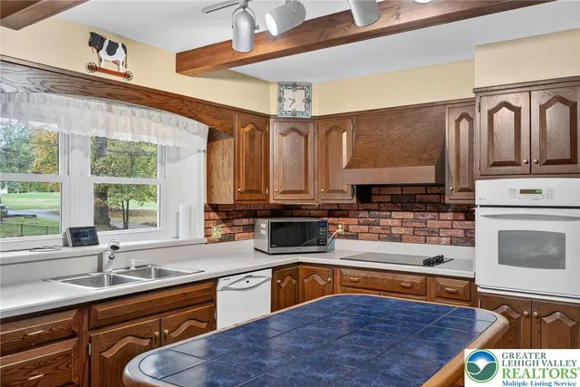 a kitchen with stainless steel appliances granite countertop a refrigerator a stove and a sink