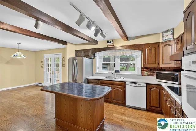 a kitchen with stainless steel appliances granite countertop a sink and a refrigerator