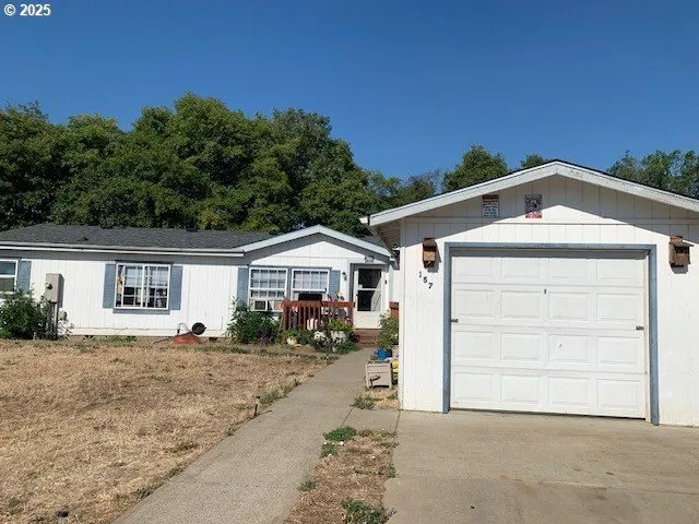 a view of wooden house with a yard and furniture