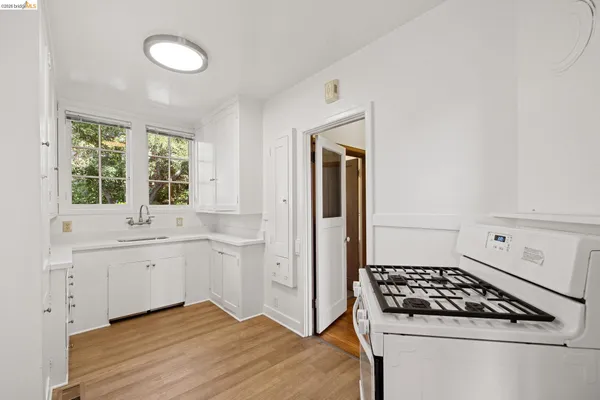 a view of empty room with wooden floor and windows