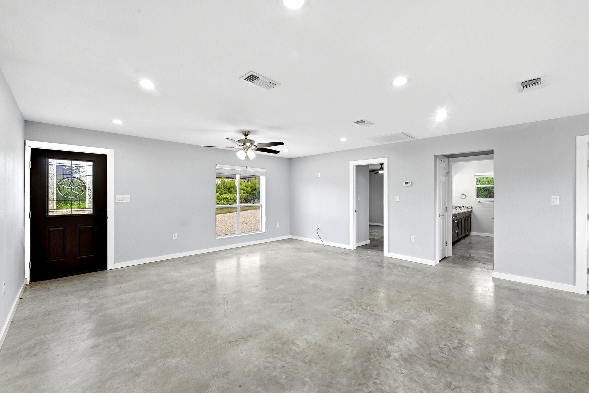 4001 Barth Road Lockhart, TX 78644 - Photo 10 of 38 Polished concrete floors and recessed lighting anchor this open entryway and living space.
