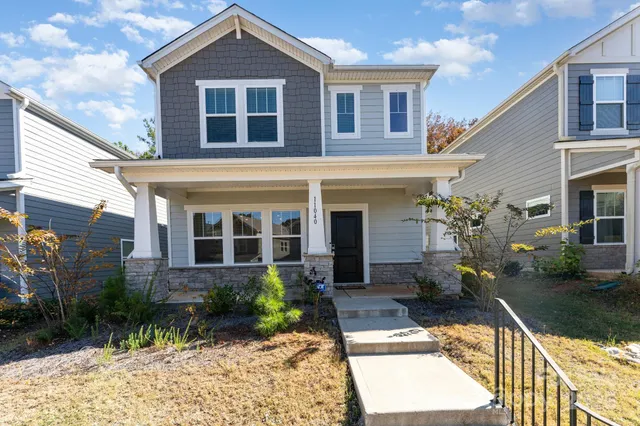 a view of a brick house with potted plants and a large window