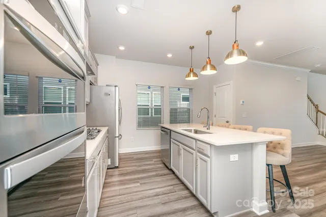 a kitchen with a sink a island a stove and a refrigerator