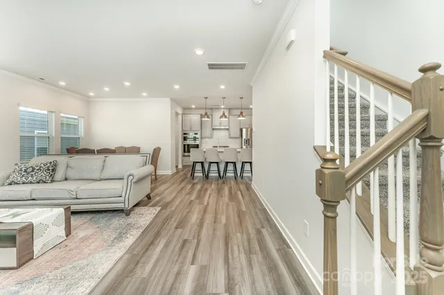 a view of a living room kitchen with furniture and wooden floor