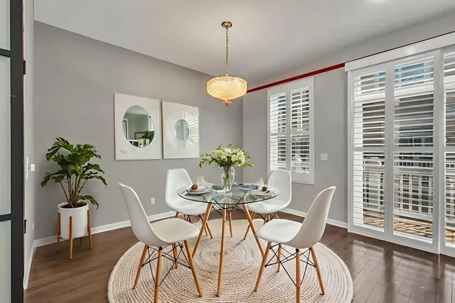 a dining room with furniture potted plants and wooden floor