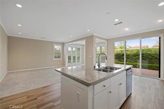 a kitchen with granite countertop a sink and dishwasher with wooden floor