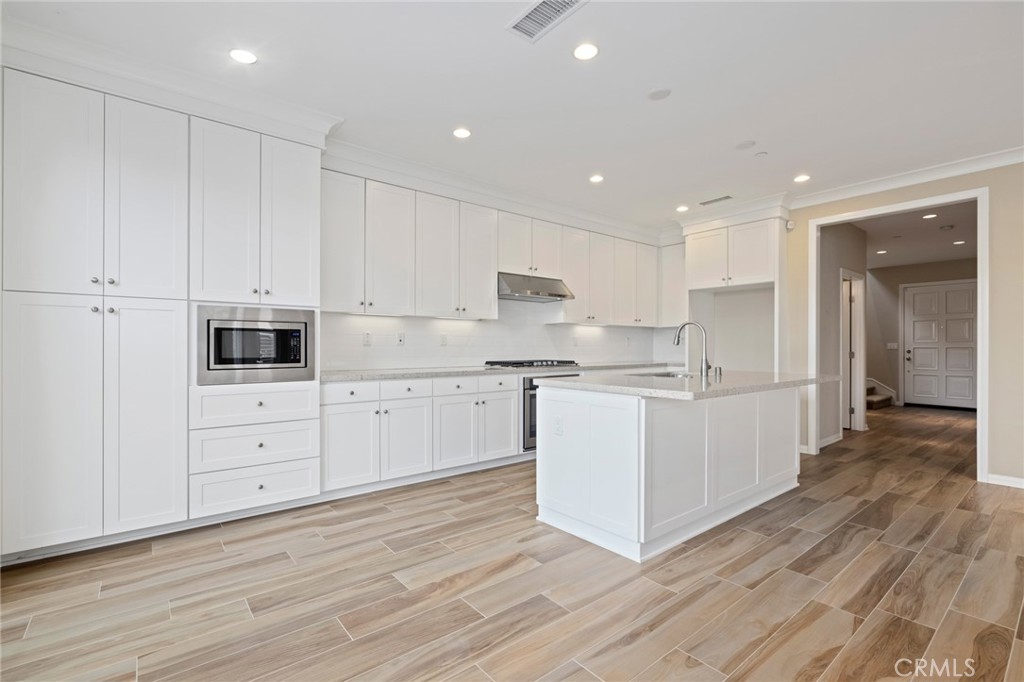 133 Waterleaf Irvine, CA 92620 - Photo 5 of 22 a kitchen with white cabinets and white appliances