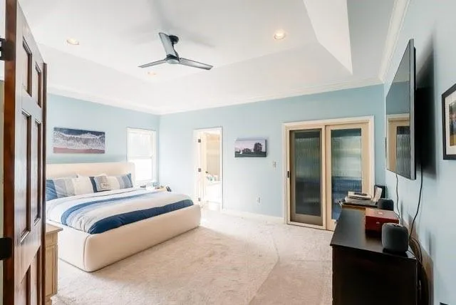 a bedroom with a bed a flat screen tv and guitar