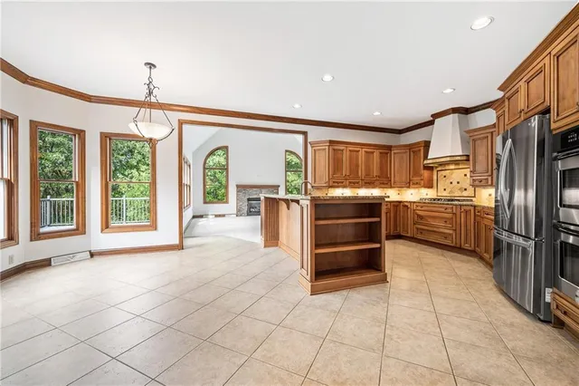a kitchen with granite countertop a refrigerator and a stove top oven