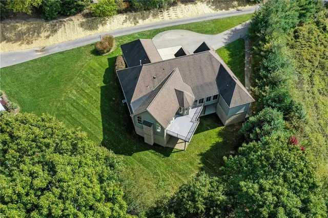 an aerial view of a house with a yard and lake view