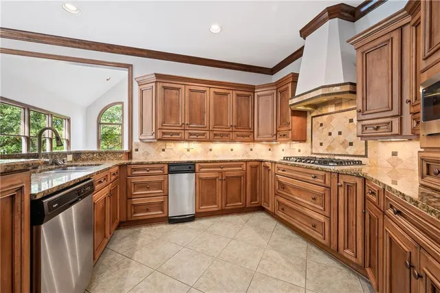 a kitchen with stainless steel appliances granite countertop a stove and a sink