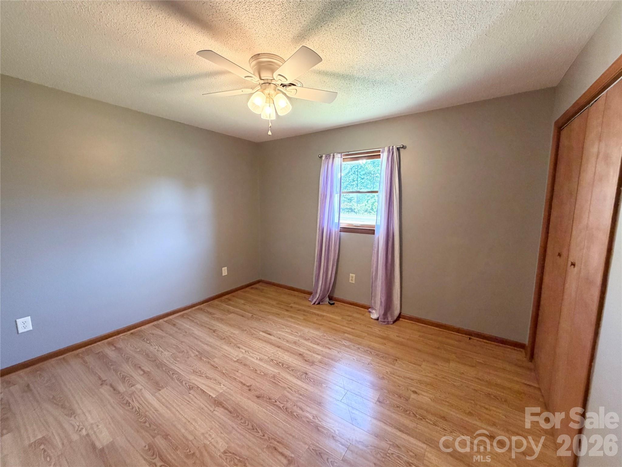 372 Ferry Road Forest City, NC 28043 - Photo 19 of 36 an empty room with wooden floor and chandelier fan