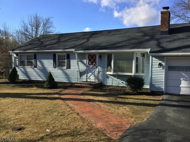 an empty room with wooden floor fireplace and windows