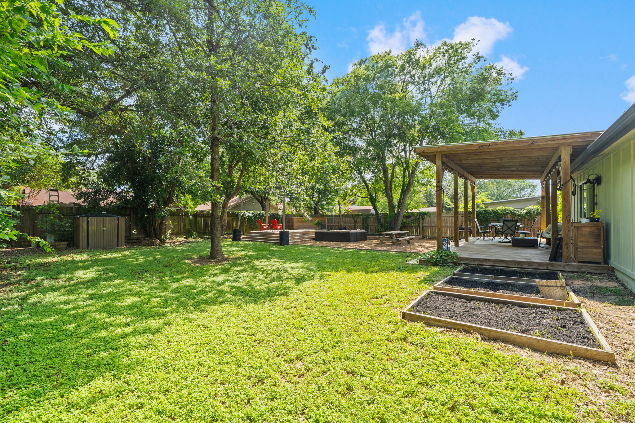 705 Dulwich Street Austin, TX 78748 - Photo 32 of 36 An inviting backyard oasis with a covered deck and dedicated garden beds awaits outdoor enjoyment.