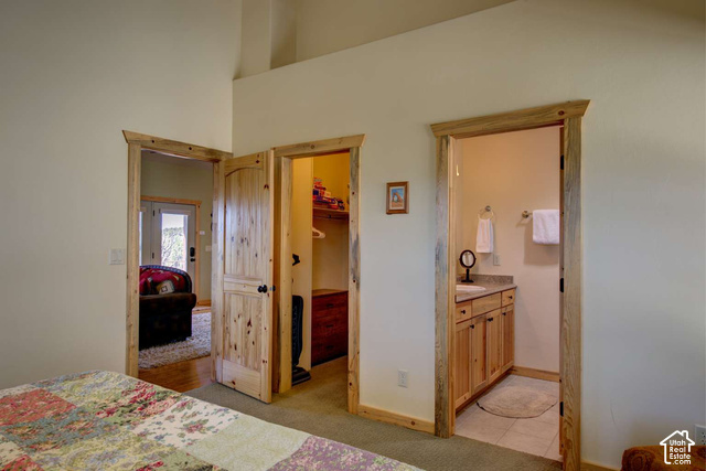 1735 West Pinyon Hls Road Hatch, UT 84735 - Photo 7 of 21 Vaulted ceiling, natural wood trim, knotty pine doors, vanity with stone countertop, and tile flooring