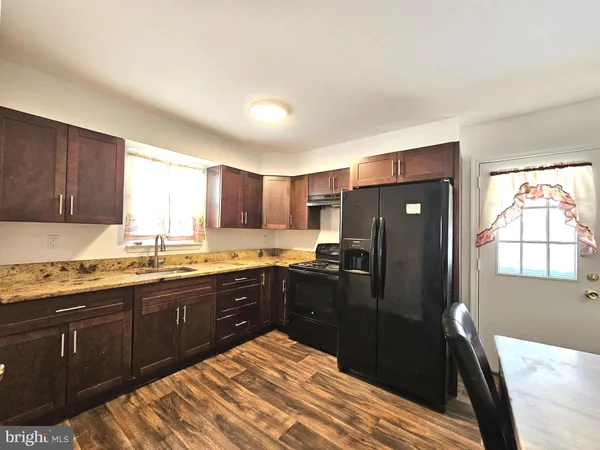 a kitchen with granite countertop stainless steel appliances and wooden cabinets