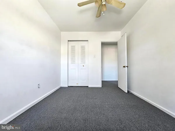 an empty room with closet and chandelier fan