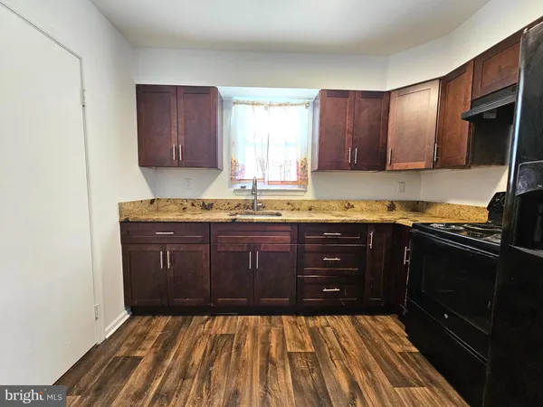 a kitchen with a sink a stove and cabinets