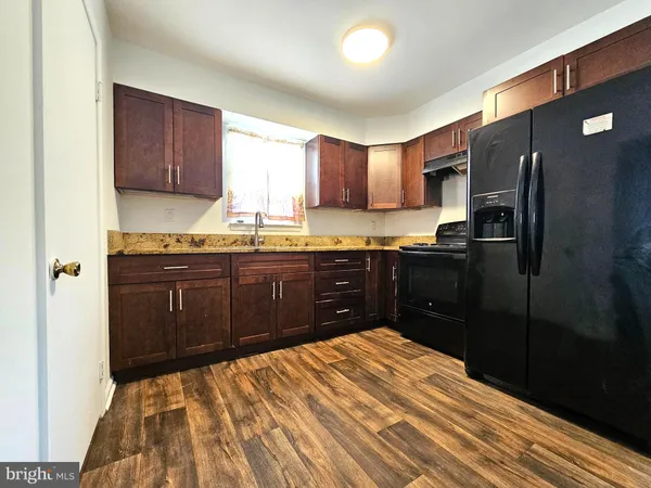 a kitchen with stainless steel appliances granite countertop a sink refrigerator and cabinets