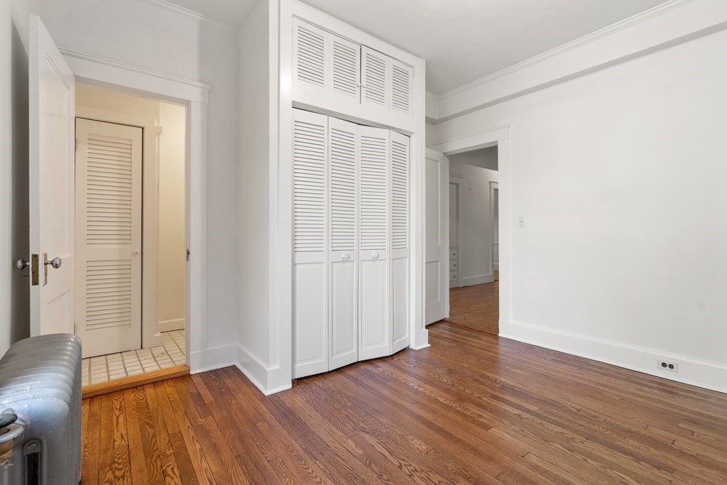 135 Freeman Street, Unit 1A Brookline, MA 02446 - Photo 12 of 22 an empty room with wooden floor