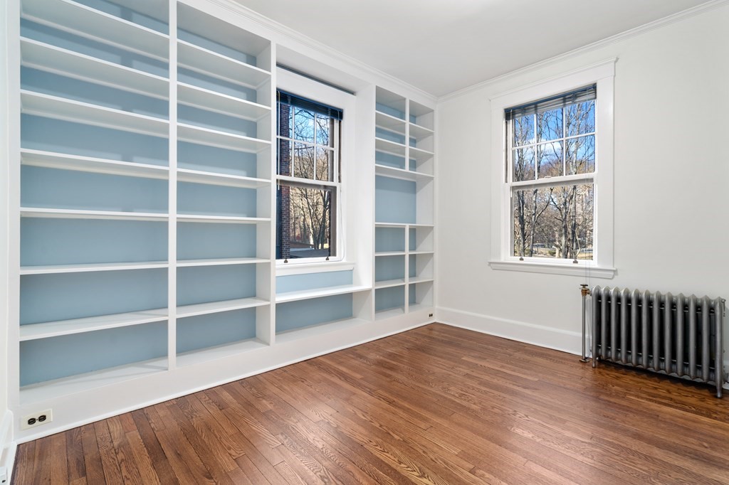135 Freeman Street, Unit 1A Brookline, MA 02446 - Photo 2 of 22 a view of an empty room with a window and wooden floor