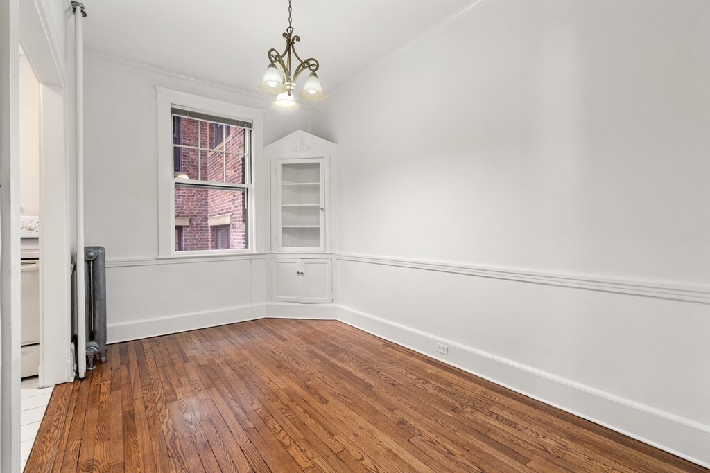 135 Freeman Street, Unit 1A Brookline, MA 02446 - Photo 3 of 22 wooden floor in an empty room with a window