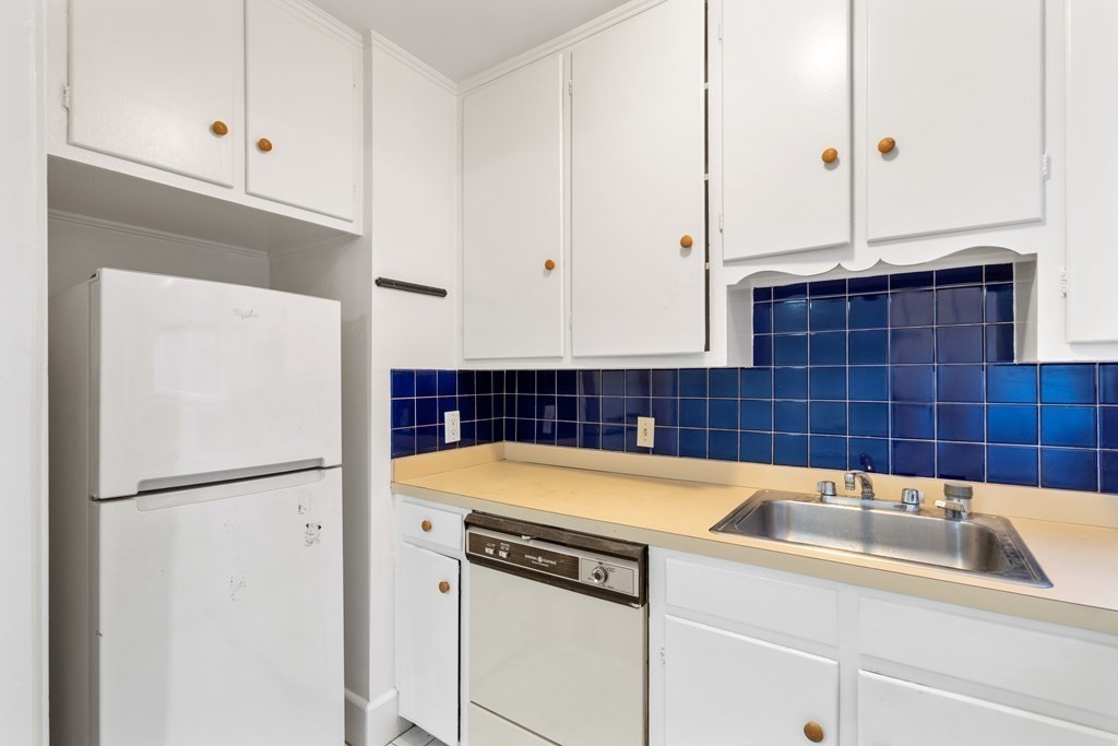 135 Freeman Street, Unit 1A Brookline, MA 02446 - Photo 7 of 22 a bathroom with a sink and a refrigerator