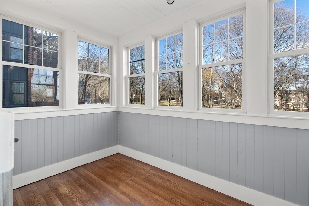 135 Freeman Street, Unit 1A Brookline, MA 02446 - Photo 8 of 22 a view of an empty room with wooden floor and windows