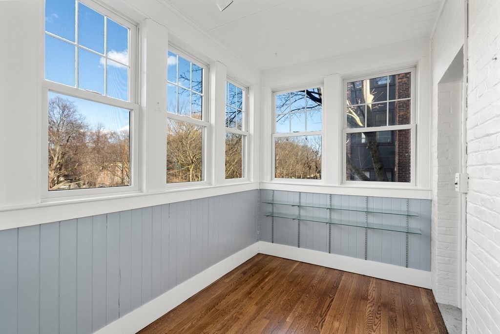 135 Freeman Street, Unit 1A Brookline, MA 02446 - Photo 9 of 22 a view of an empty room with a window and wooden floor
