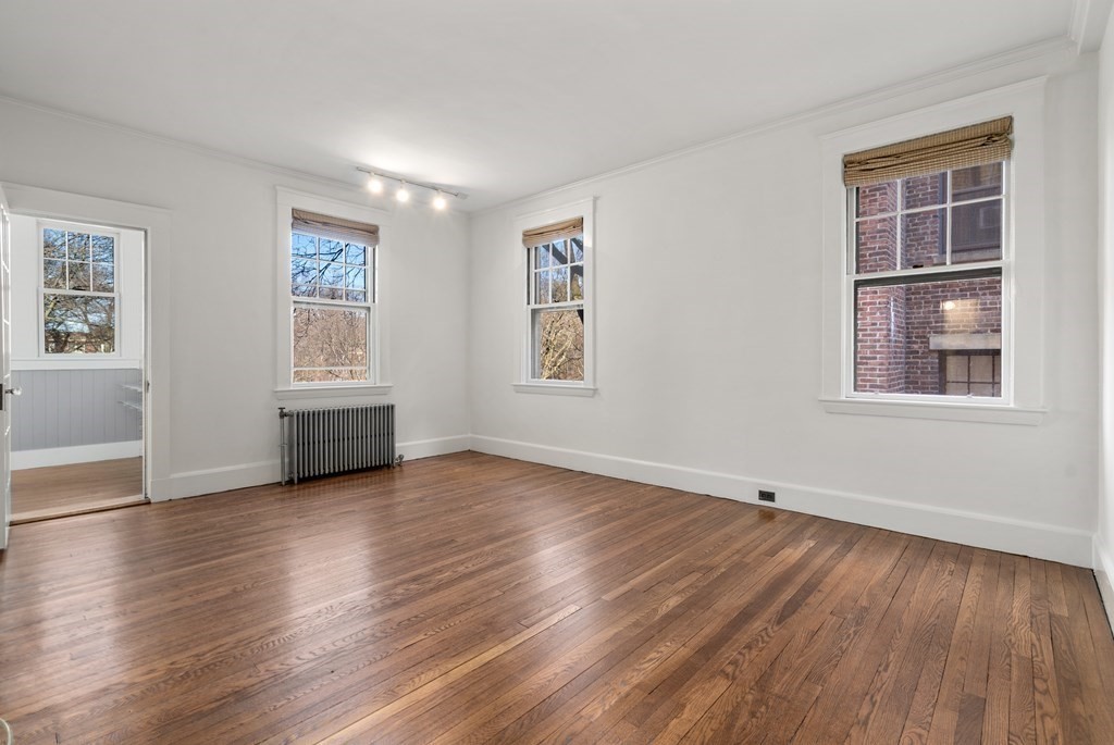 135 Freeman Street, Unit 1A Brookline, MA 02446 - Photo 10 of 22 a view of an empty room with wooden floor and a window