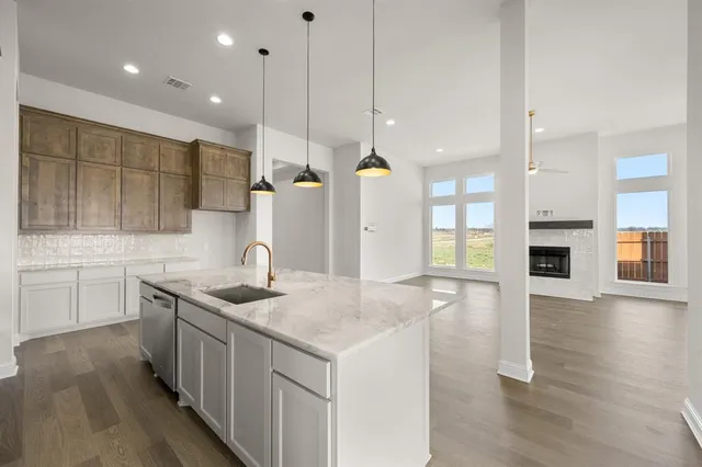 a kitchen with a sink a counter space and wooden floor