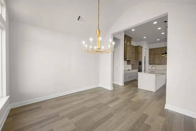 a view of a room with wooden floor and kitchen view