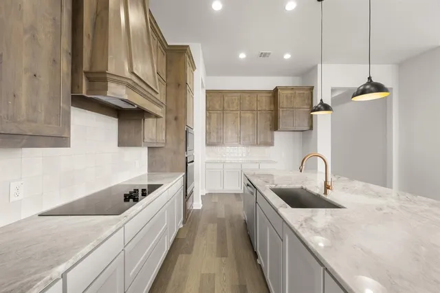 a kitchen with a sink a counter top space stainless steel appliances and cabinets