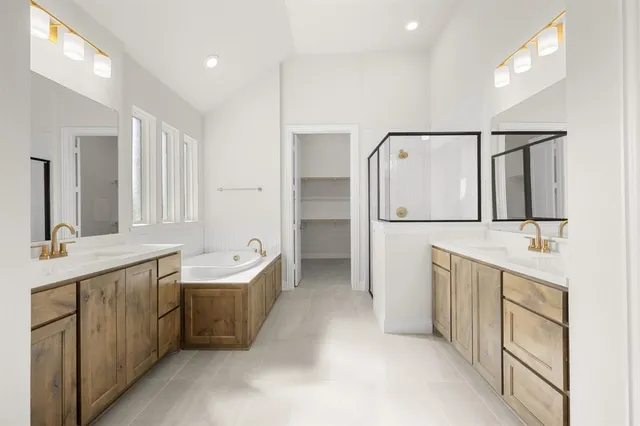a spacious bathroom with a double vanity sink a mirror and a bathtub