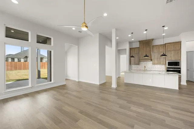 a view of kitchen with kitchen island wooden floor center island and appliances